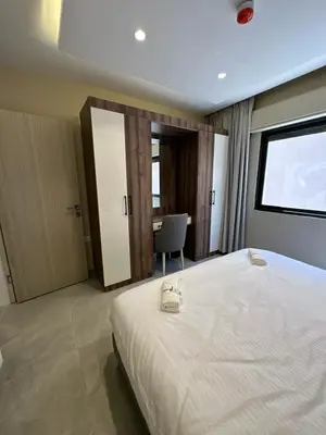 a bedroom with a bed and a desk in it at Chic Apartments For Rent ave0-8 in Umm Uthainah