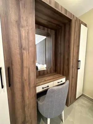 a vanity with a mirror and a chair in a room at Chic Apartments For Rent ave0-9 in Amman