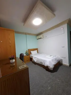 a hotel room with a bed and a desk and a room at Azmal Hotel & Suites in Irbid