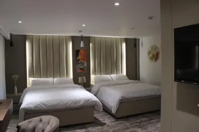 a bedroom with two beds and a flat screen tv at Azmal Hotel & Suites in Irbid