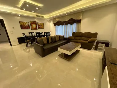 a living room with a couch and a table at 2 En-suite Rooms, Central & Garden Terrace in Amman