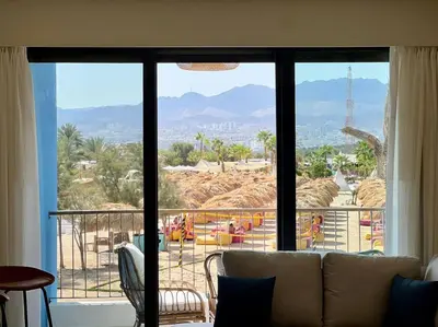a living room with a couch and a large window at Luxury Apt with Private Beach In Ayla in Aqaba