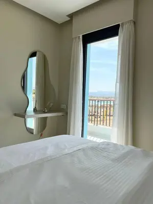 a bedroom with a bed and a large window at Luxury Apt with Private Beach In Ayla in Aqaba