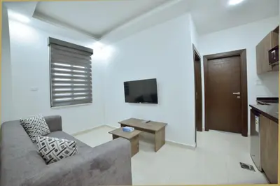 a living room with a couch and a tv at رمّ للأجنحة Rum Royal Suites in Irbid