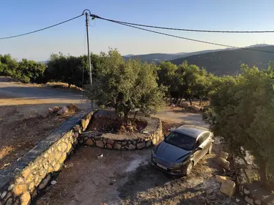 a car parked in a parking lot next to a wall at فيلا بيت الجبل in Ishtafaynā