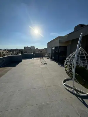 a view of a rooftop with chairs on a building at The Roof Top Lounge in Umm Uthainah