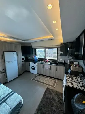 a kitchen with a white refrigerator and a stove at The Roof Top Lounge in Umm Uthainah