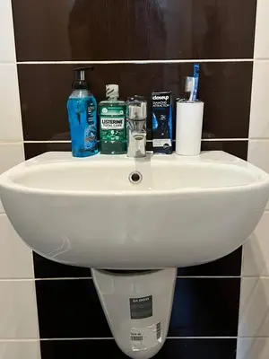 a white sink in a bathroom with toiletries on it at Cozy & Comfortable Studio in the heart of Amman, Studio #17 in Umm Uthainah
