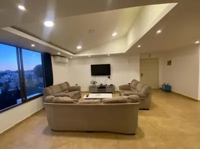 a living room with two couches and a flat screen tv at The view IVI in Umm Uthainah