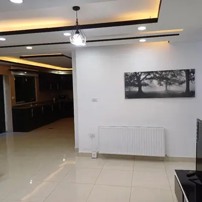 a room with a white wall and a picture on the wall at Laperla family apartment 1 in Al Yādūdah