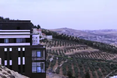 a building on the side of a hill with a vineyard at villa rose3 in Mūbiş
