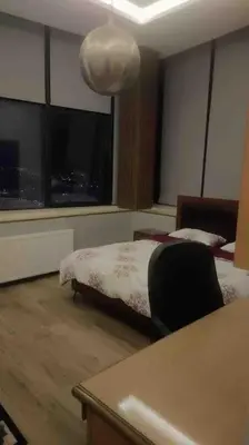a bedroom with a bed and a table with a chair at villa rose3 in Mūbiş