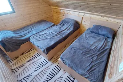 two beds sitting inside of a wooden room at أكواخ وشقق كرم العنب عجلون in ‘Ayn Jannā