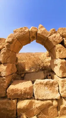 an arch in a stone wall with a sky at Ramses Tafilah Lodge نزل رمسيس الطفيلة in At-Tafilah