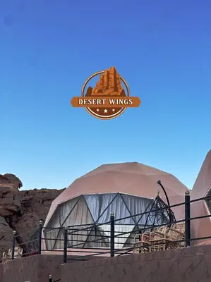 a domed building with a sign that reads desert wings at RUM WINGS BUBBLES lUXURY CAMP in Wadi Rum