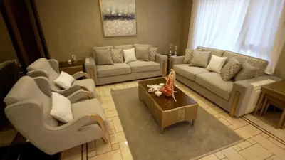 a living room with couches and a coffee table at Open sooq in Al Bunayyāt ash Shamālīyah