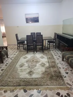 a dining room with chairs and a table and a piano at Al Otaibi in Umm Uthainah
