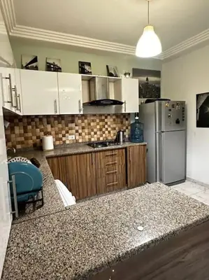 a kitchen with white cabinets and a refrigerator at Cozy modern 2 bedroom apartment in Amman