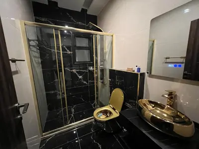 a bathroom with a toilet and a sink and a shower at Modern & New 3-BR Entire Apt - Prime Location! in Rujm ash Sharāʼirah
