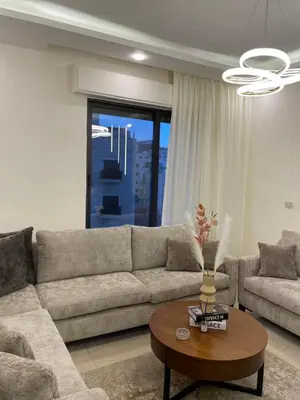 a living room with a couch and a table at السابع in Amman