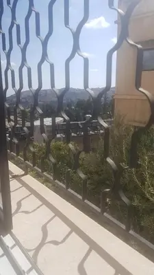 a fence with a view of the city at ram77 in Al Salt