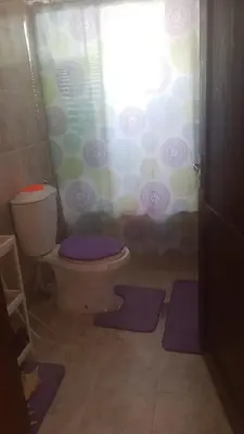 a bathroom with a toilet and a shower curtain at ram77 in Al Salt