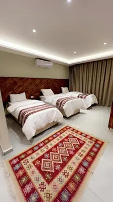 two beds in a room with a rug on the floor at Jawad Hotel by Sandra in Amman