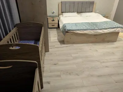 a bedroom with a bed and a wooden floor at Aeropuerta Mini Villa - Private self check-in Layover near Airport in Al Qasţal
