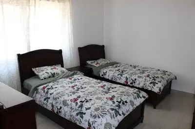two beds sitting in a room with curtains at Cosy appartement in Umm Uthainah