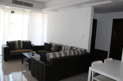 a living room with a couch and a table at Cosy appartement in Umm Uthainah