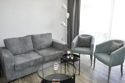 a living room with a couch and two chairs and a table at Cozy apartment Amman in Umm Uthainah