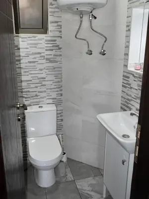 a bathroom with a toilet and a sink at Cozy apartment Amman in Umm Uthainah