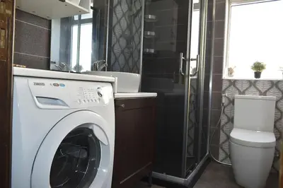 a bathroom with a washing machine and a sink at Cozy apartment Amman in Umm Uthainah