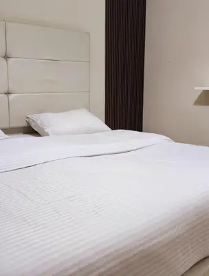 a close up of a white bed in a bedroom at Flat In Shafa Badran in Ţāb Kirā‘