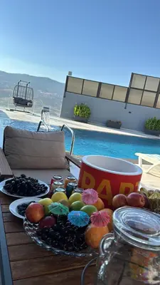a table with a plate of fruit and a cup at شاليه بيت التل HILLHOUSE Chalet in Al Maşţabah