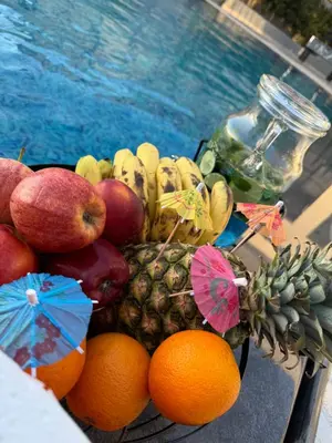 a pile of fruit on a table next to a pool at شاليه بيت التل HILLHOUSE Chalet in Al Maşţabah