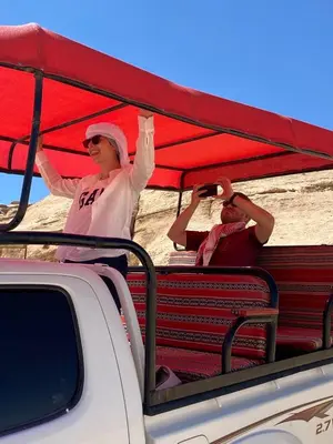a woman standing on the back of a truck with a red umbrella at Moon rum 2 in Disah