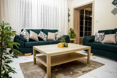 a living room with blue couches and a coffee table at Hawari Group in Umm Uthainah
