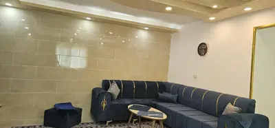 a living room with a blue couch and a table at ستوديو مستقل داخل فيلا in Amman