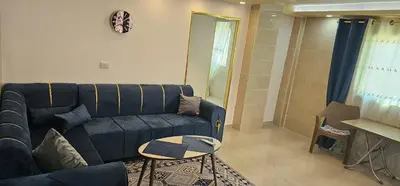 a living room with a blue couch and a table at ستوديو مستقل داخل فيلا in Amman