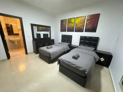 a bedroom with two beds and a sink at 2 En-suite Rooms, Central & Spacious in Amman