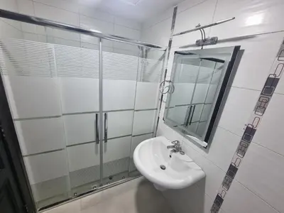 a white bathroom with a sink and a mirror at Dier Ghbar 2 bedrooms-A in Amman