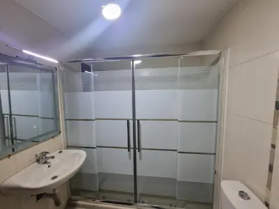 a bathroom with a glass shower and a sink at Dier Ghbar 2 bedrooms-A in Amman