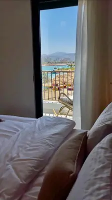 a bedroom with a bed and a view of a balcony at Aladdin Chalet 13 in Aqaba