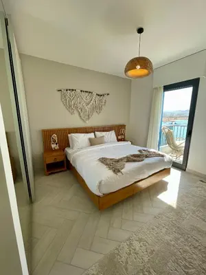 a bedroom with a large bed and a balcony at Aladdin Chalet 13 in Aqaba