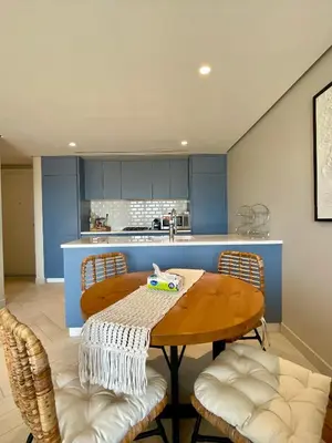 a kitchen with a wooden table and chairs at Aladdin Chalet 13 in Aqaba