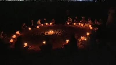 a group of people sitting around a table with candles at Camp star road safari in Wadi Rum