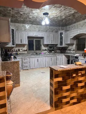 a large kitchen with white cabinets and a ceiling at Indiana Jones Home Stay in Petra