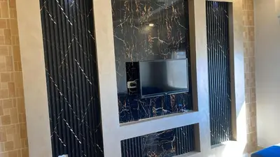 a tv in a wall with black glass at Izz AlDin Tamimi St شقة مفروش سوبر ديلوكس الجبيهة in Ţāb Kirā‘