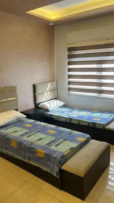 two beds sitting in a room with a window at Izz AlDin Tamimi St شقة مفروش سوبر ديلوكس الجبيهة in Ţāb Kirā‘